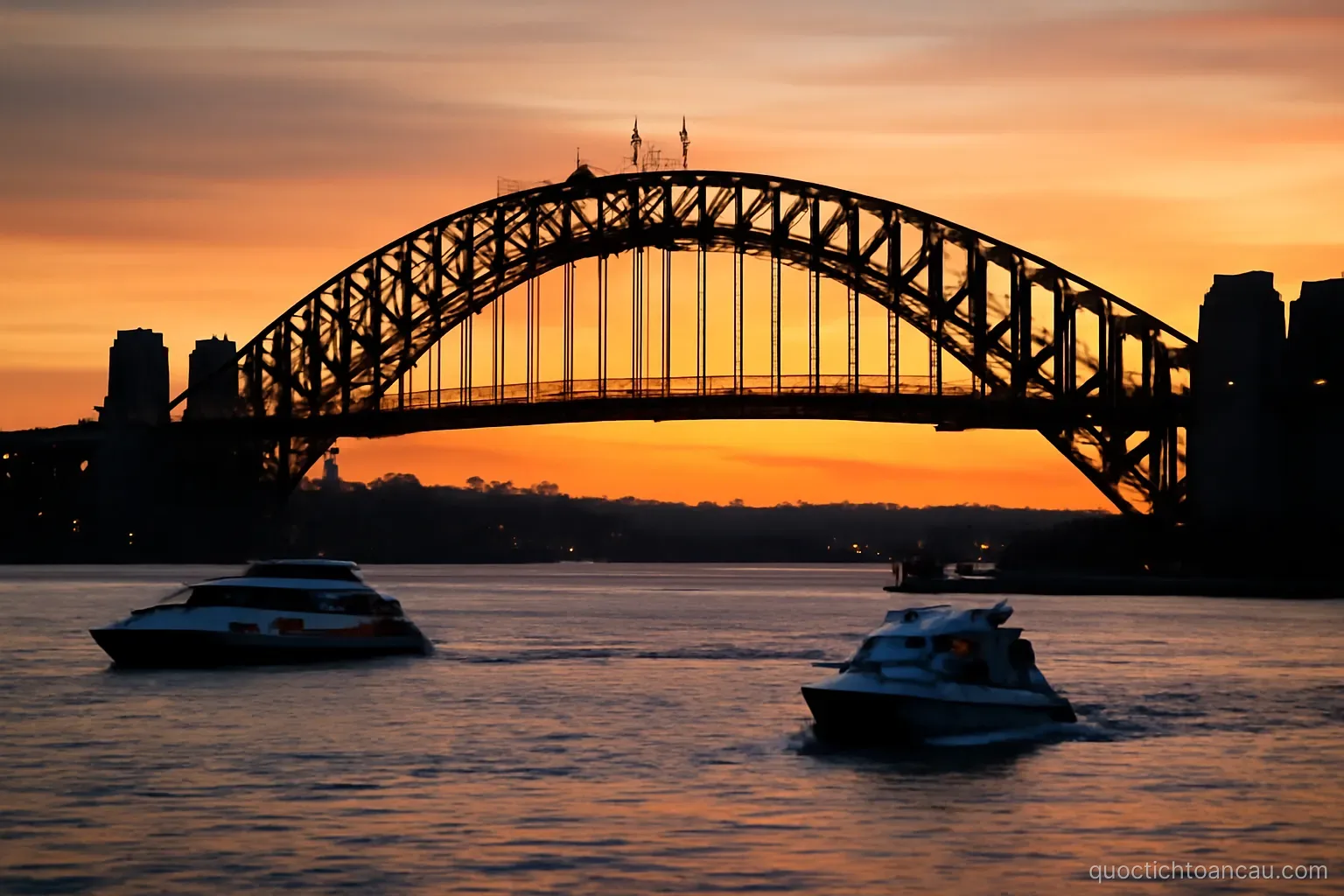 a harbour bridge silhouetted at dusk with boats moving on the water below