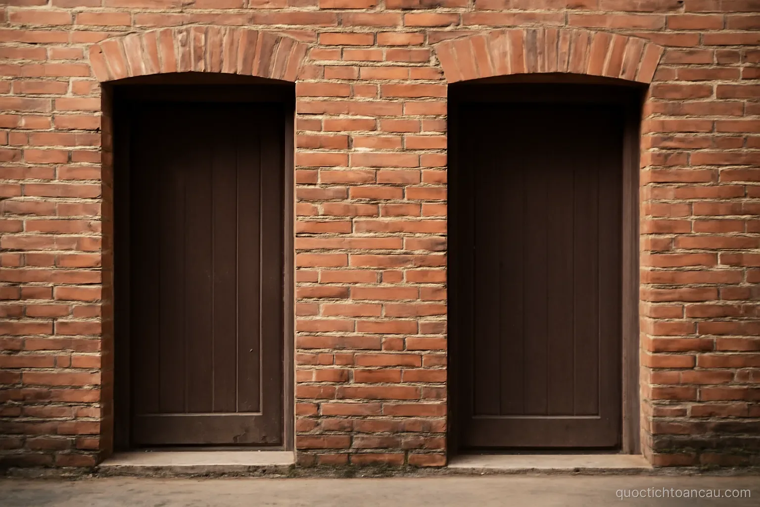 two doorways side by side in a brick wall, one slightly wider than the other